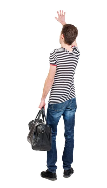 Costas do homem com um saco balançando em saudação. — Fotografia de Stock