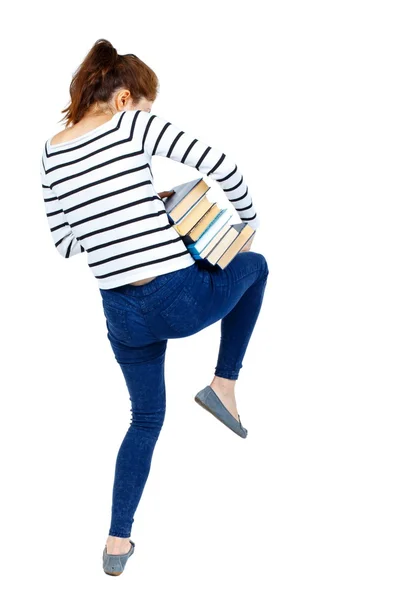 Kız ağır bir yığın kitap taşır. Arkadan Görünüm. — Stok fotoğraf