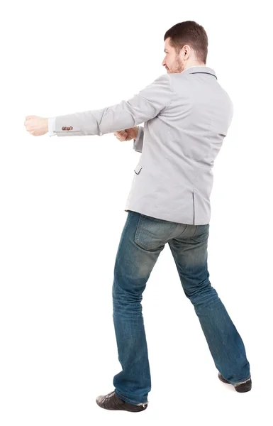 Back view of standing man pulling a rope from the top or cling t — Stock Photo, Image