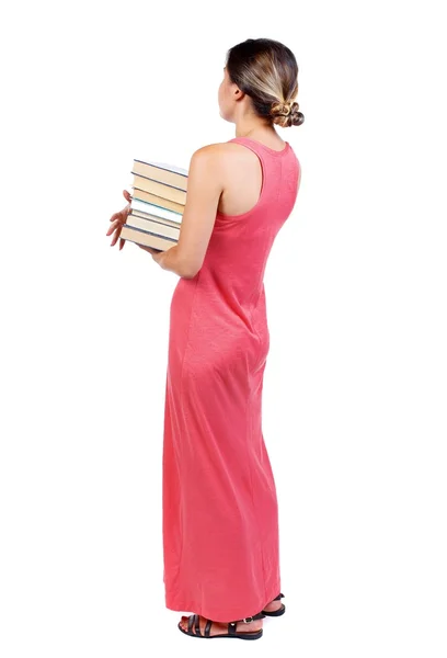 Mädchen trägt einen schweren Stapel Bücher. Ansicht von hinten. — Stockfoto