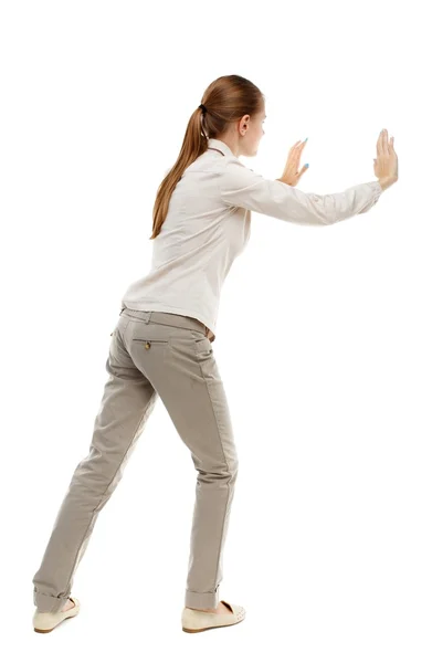 Back view of woman pushes wall. — Stock Photo, Image