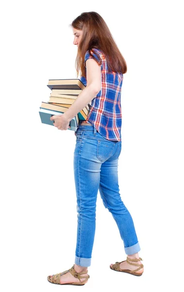 Ragazza porta un mucchio pesante dei libri. vista posteriore. — Foto Stock