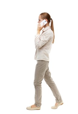 side view of woman walking with a mobile phone.