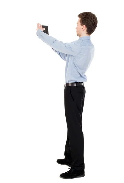Vista de homem de negócios permanente fotografando um telefone ou tabl traseira — Fotografia de Stock