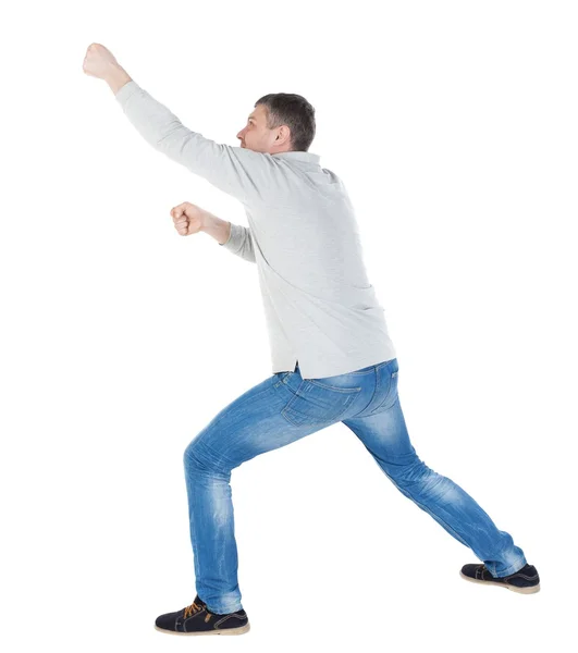 Back view of standing man pulling a rope from the top or cling t — Stock Photo, Image