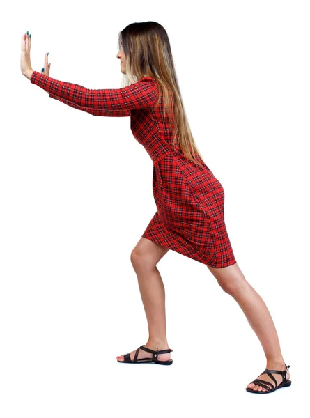 Back view of woman pushes wall. — Stock Photo, Image