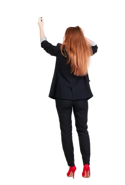 Back view of writing beautiful redhead business woman. — Stock Photo, Image