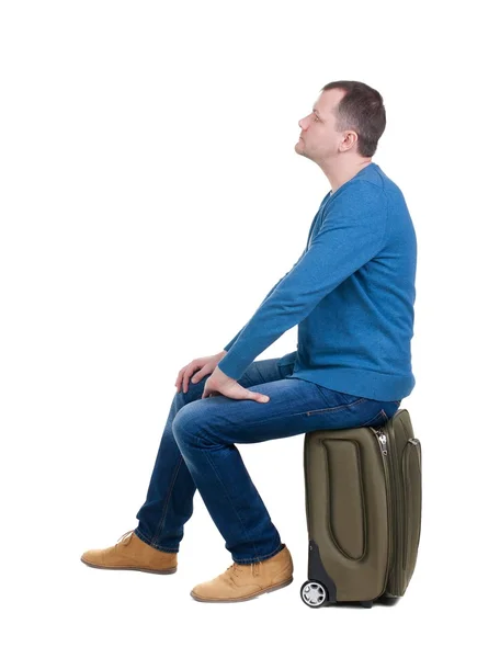 Bakifrån av en man sittande på resväska. — Stockfoto