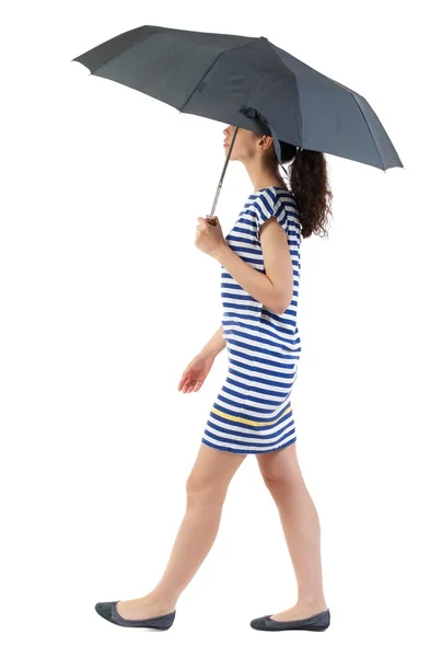 Jovem mulher de vestido andando sob um guarda-chuva. — Fotografia de Stock