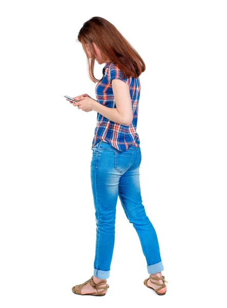 Vista posterior de pie hermosa joven con un móvil phon — Foto de Stock