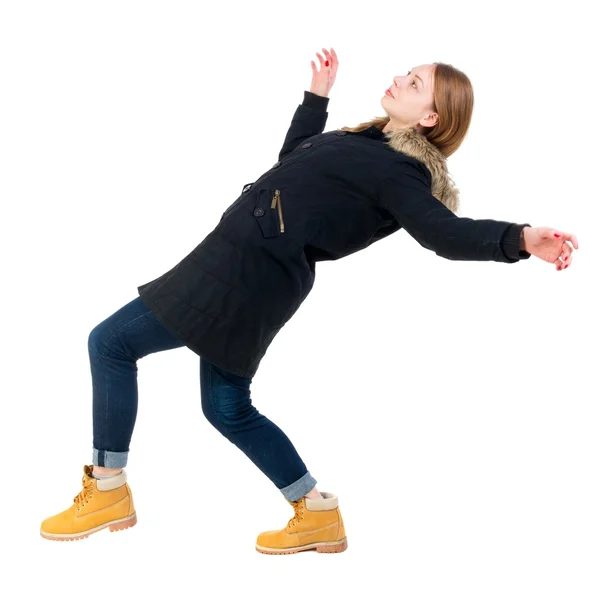 Bakifrån kvinna i vinterjacka balanserar vifta med armarna. — Stockfoto