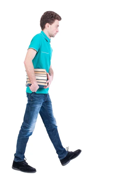 Side view going man carries a stack of books. — Stock Photo, Image