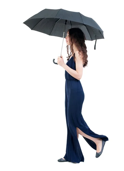 Jovem mulher de vestido andando sob um guarda-chuva. — Fotografia de Stock