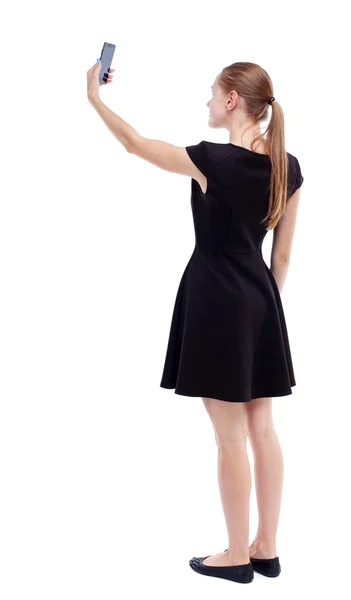 モバイル フォーを使用して立っている若い美しい女性の背面図 — ストック写真