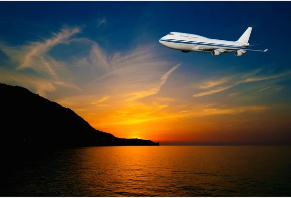 Passagerare flygplan i molnen vid solnedgången — Stockfoto
