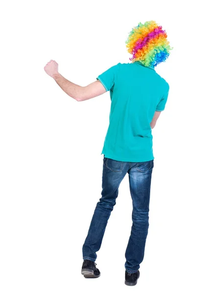 Вид ззаду танцюючого молодого красивого чоловіка в клоунній перуці . — стокове фото