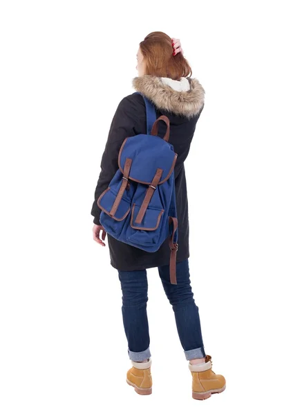 Mujer vista trasera en la chaqueta de invierno con una mochila mirando hacia arriba — Foto de Stock
