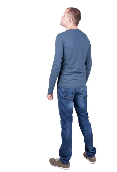 T シャツとジーンズを探している若い男の背面図. — ストック写真
