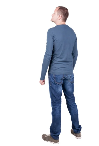 Back view of young man in t-shirt and jeans  looking. — Stock Photo, Image