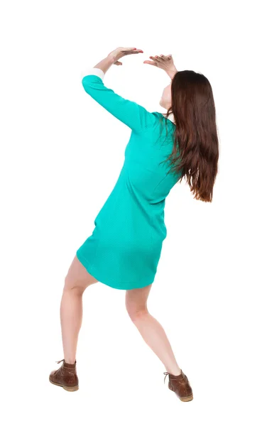 Back view woman in a dress protects hands from what is falling f — Stock Photo, Image