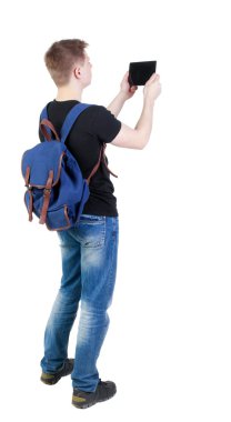 Arkadan görünüş tablet bilgisayar ve backpac genç adamla ayakta