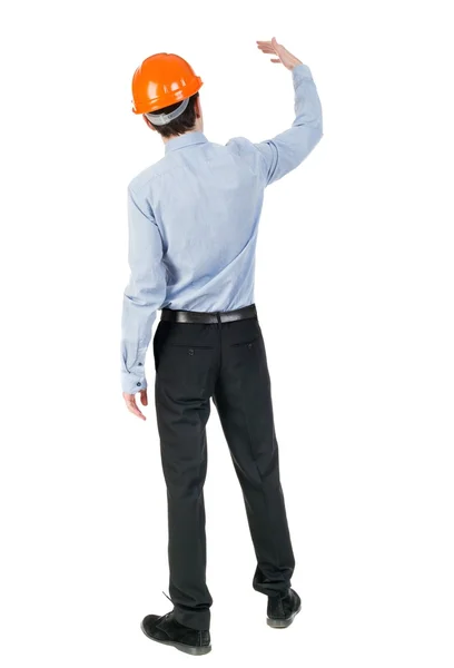 Backview of an engineer in construction helmet stands. Standing — Stock Photo, Image