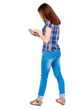 arkadan görünüşü mobil bir fon kullanan duran genç güzel kadın