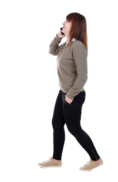 Zijaanzicht van de vrouw lopen met mobiele telefoon. — Stockfoto