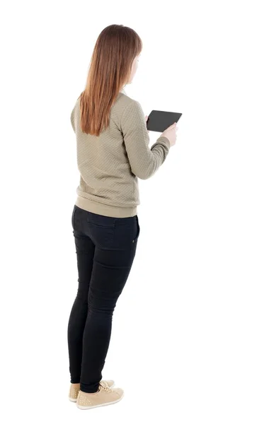Pohled zezadu na stojící krásná mladá dívka s tabletovým počítačem — Stock fotografie