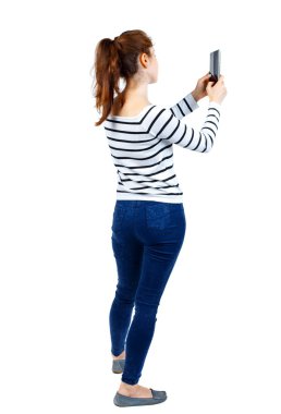 arkadan görünüşü bir mobil pho kullanan duran genç güzel kadın