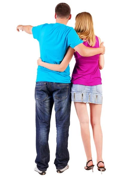 Back view of young couple pointing at wall — Stock Photo, Image