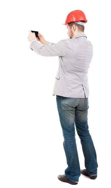 Backview of business man in construction helmet stands and enjoy — Stock Photo, Image