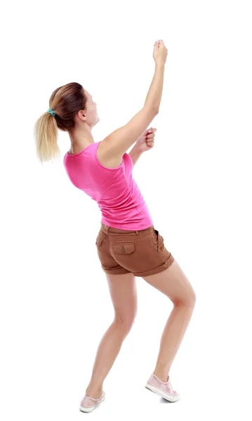 Back view of standing girl pulling a rope from the top or cling — Stock Photo, Image