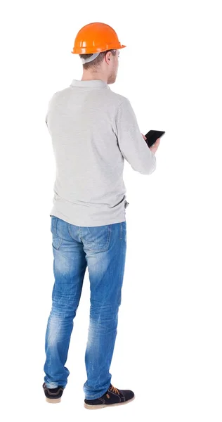 Young engineer in a protective helmet with tablet computer in th — Stock Photo, Image