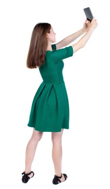 arkadan görünüşü bir mobil pho kullanan duran genç güzel kadın