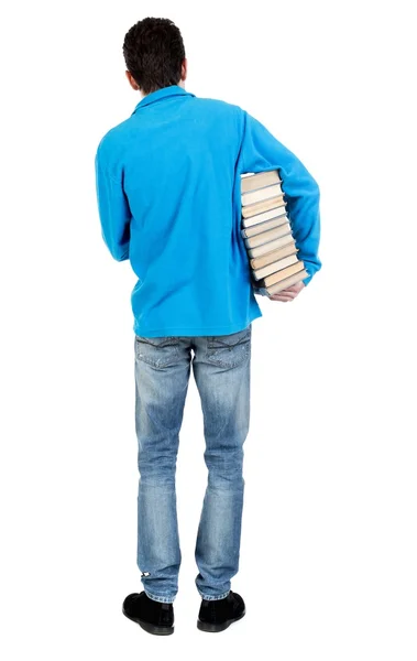 Člověk nese těžkou hromadu knih. — Stock fotografie