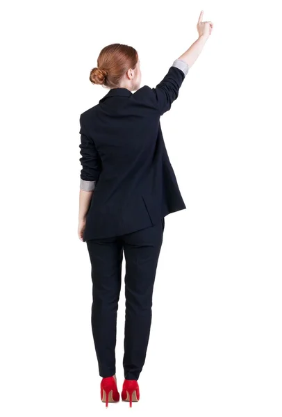 Back view of young redhead business woman pointing at wal — Stock Photo, Image