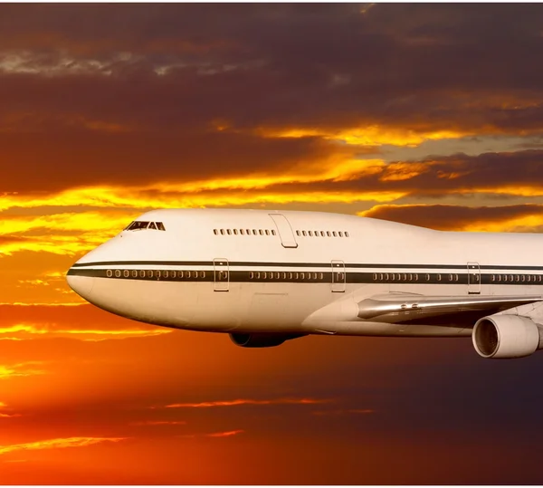 Αεροπλάνο επιβατών στα σύννεφα στο ηλιοβασίλεμα ή την αυγή. — Φωτογραφία Αρχείου