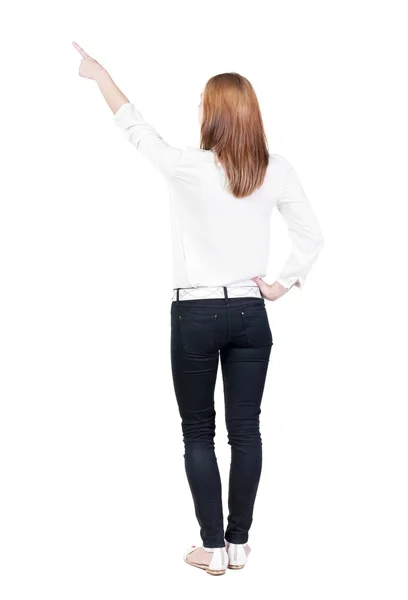 Back view of young brunette woman pointing at wall. beautiful gi — Stock Photo, Image
