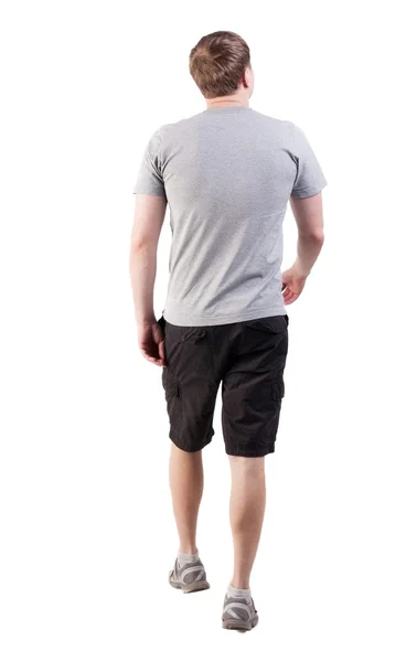Vista posterior de caminar hombre guapo en pantalones cortos y zapatillas — Foto de Stock