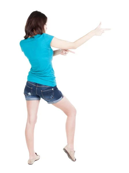 Baksidan på pekar kvinna. vackra brunett tjej i shorts — Stockfoto