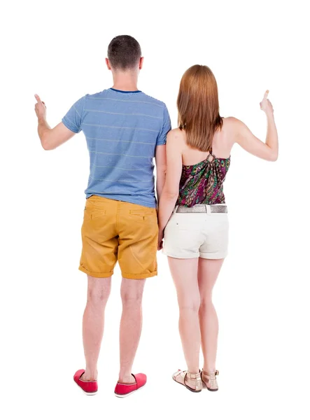 Young couple pointing at wal Back view — Stock Photo, Image