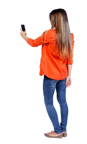 Back view of standing young beautiful  woman  using a mobile pho — kuvapankkivalokuva