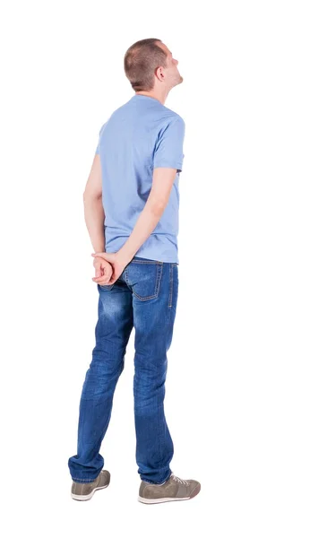 Bakifrån av ung man i t-shirt och jeans ser. — Stockfoto