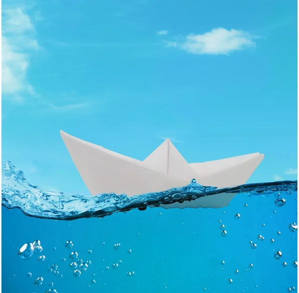 Barco de papel flotando entre las olas en el océano — Foto de Stock