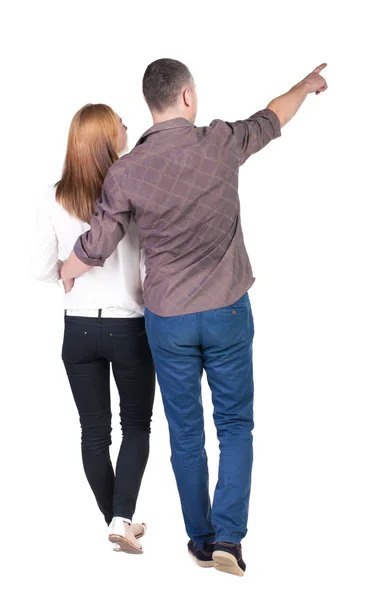 Bakifrån Walking ungt par (man och kvinna) pekar. — Stockfoto