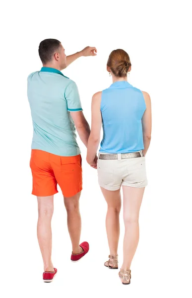 Caminando y señalando la joven pareja vista posterior — Foto de Stock