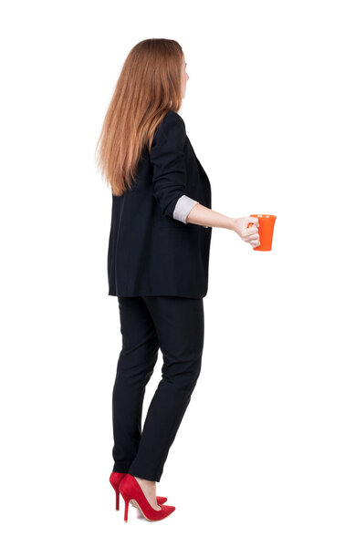 Rear view of a young business woman drinking coffee or tea while