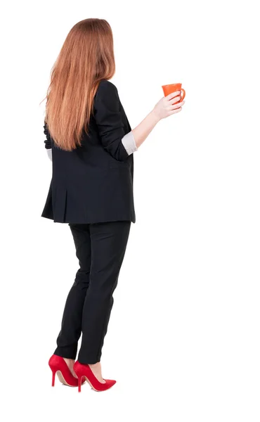 Rear view of a young business woman drinking coffee or tea while — Stock Photo, Image