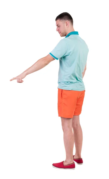 Bakifrån pekar unga män i t-shirt och shorts. — Stockfoto